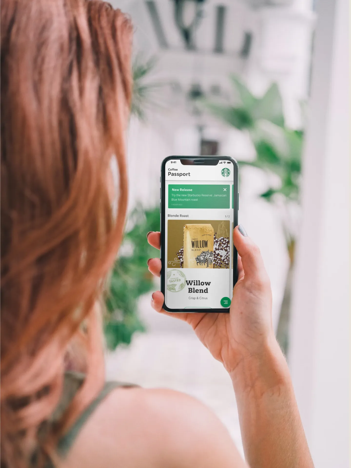 Over the shoulder photo showing a woman looking at the app on a mobile device